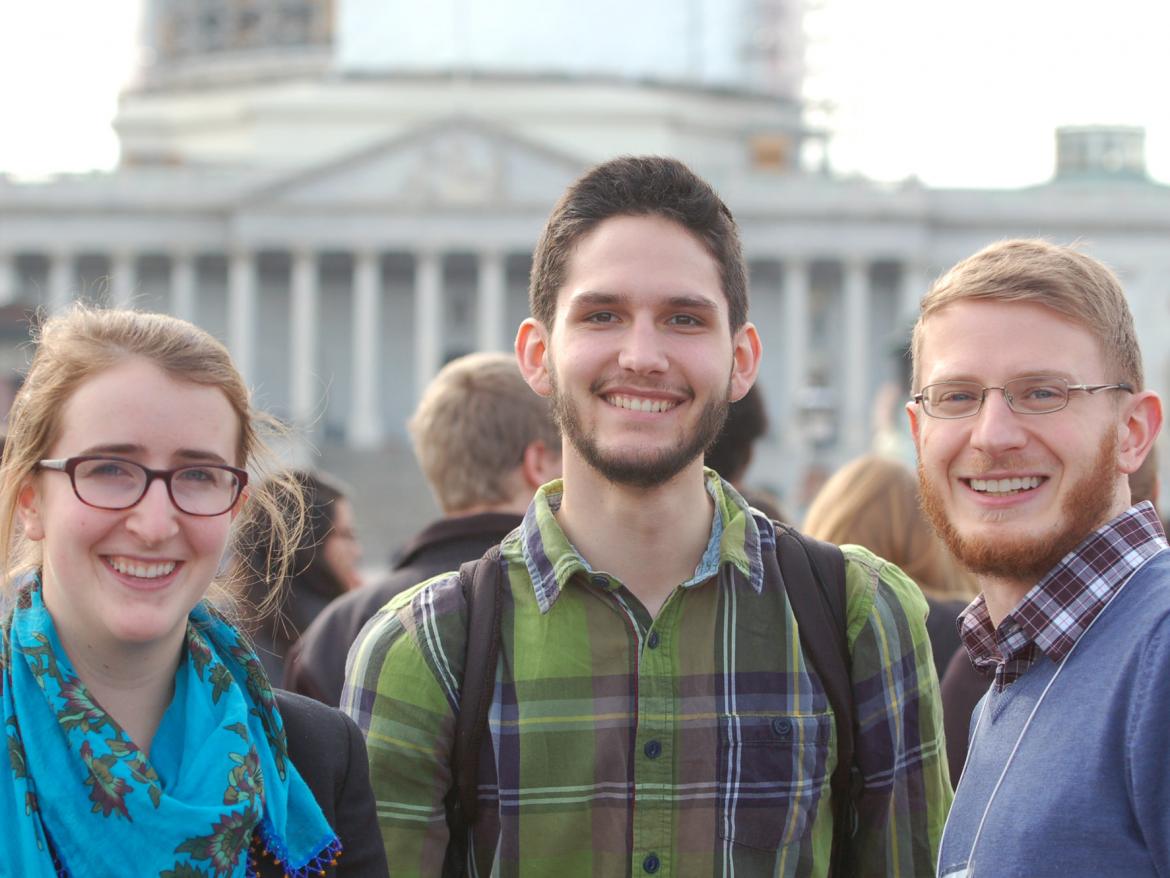 Three students smile in front of U.S. Capitol
