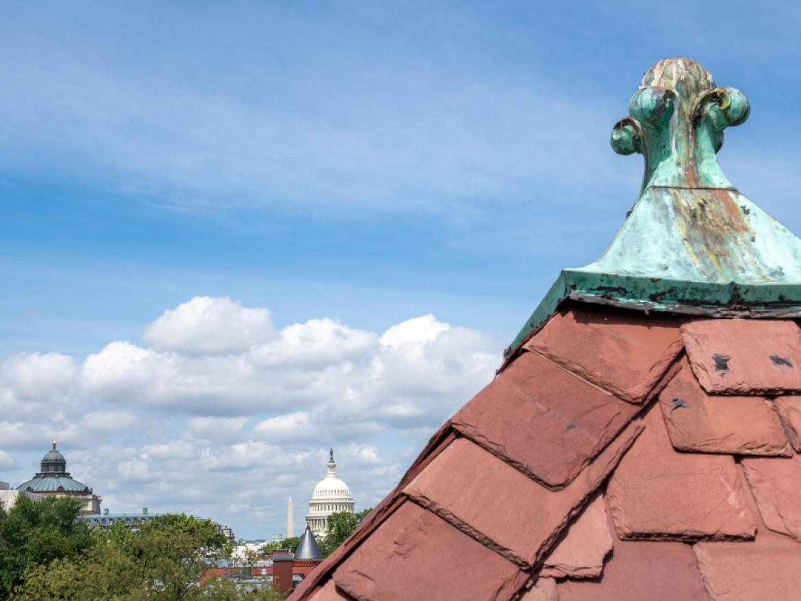 The finial on the roof of Friends Place on Capitol Hill is in the foreground, with the Capitol and Washington Monument nearby.