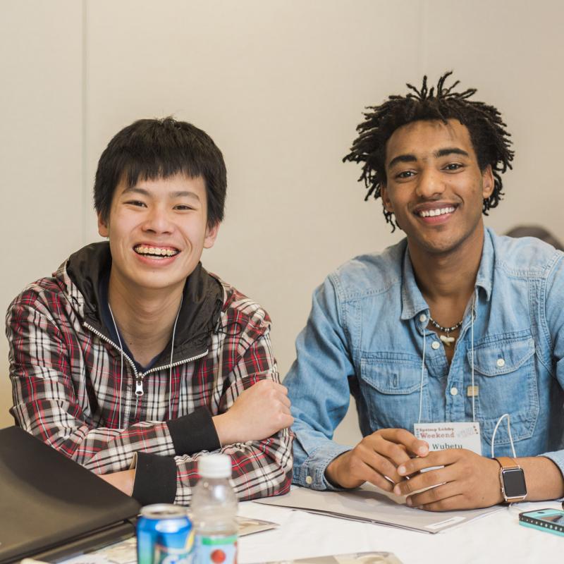 Three students smiling at a table