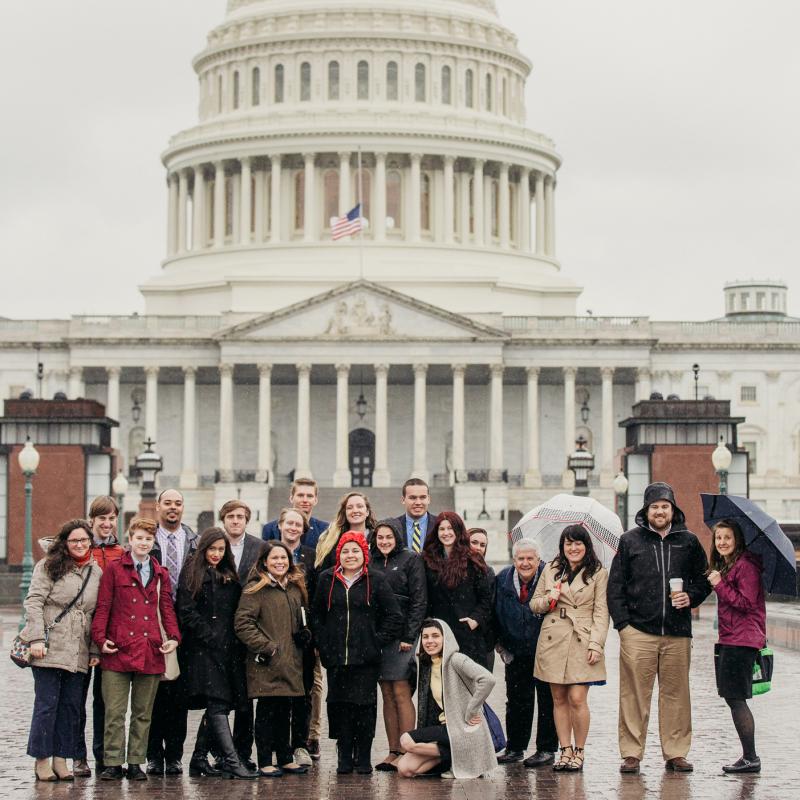 Students pose in the rain in front of U.S. Capitol
