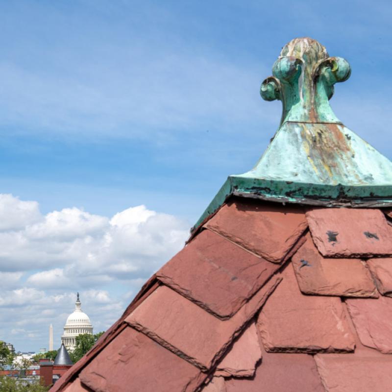 The finial on the roof of Friends Place on Capitol Hill is in the foreground, with the Capitol and Washington Monument nearby.