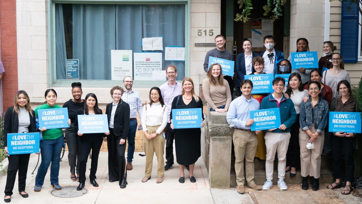 FCNL Advocacy Corps organizers stand outside Friends Place holding "Love Thy Neighbor" signs